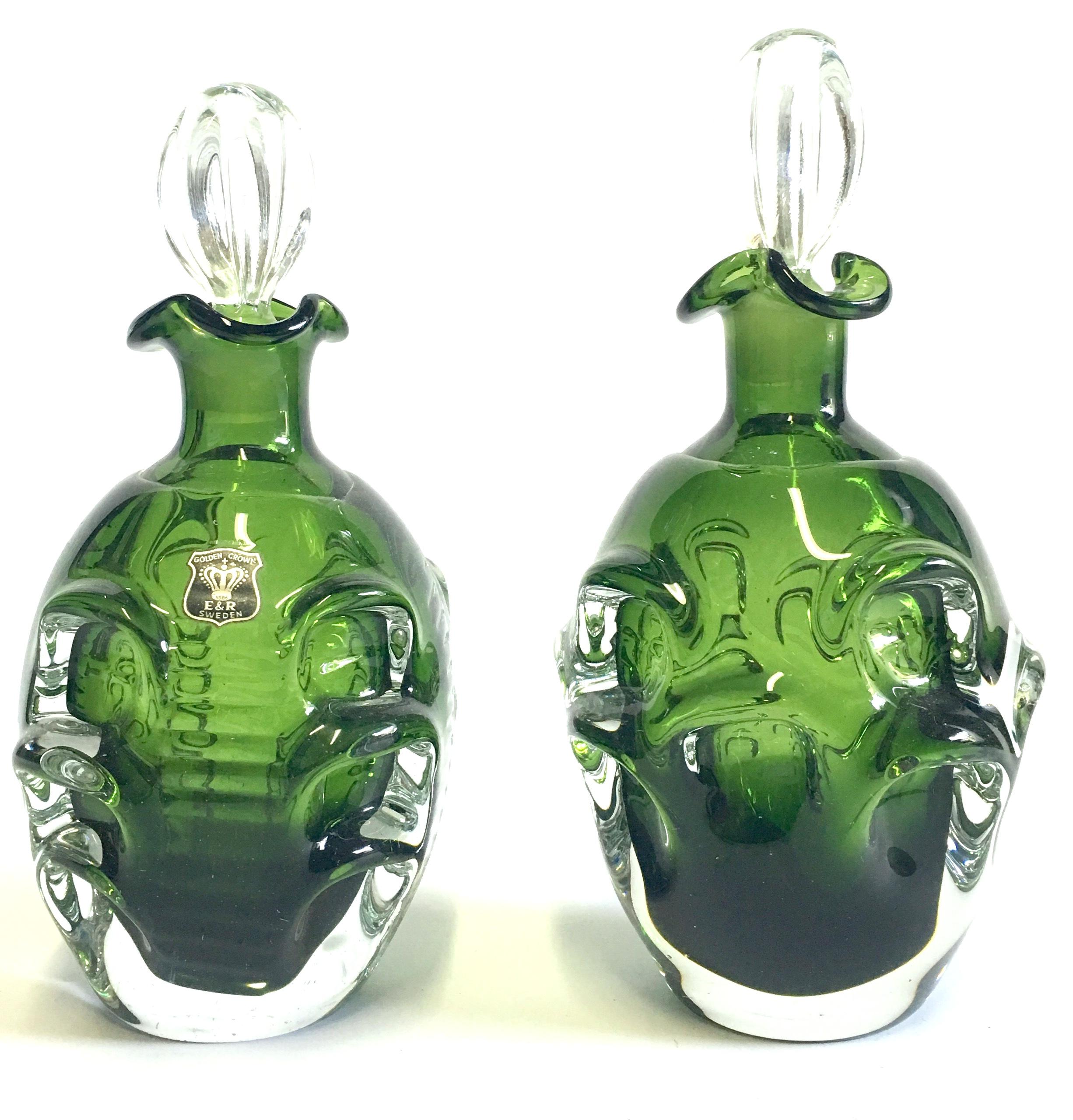 Mid-20th century modern pair of Swedish cut crystal liquor decanters by Bo Borgstrom for Aseda. The pair differentiates in size, slightly. The smaller decanter is smaller by .50