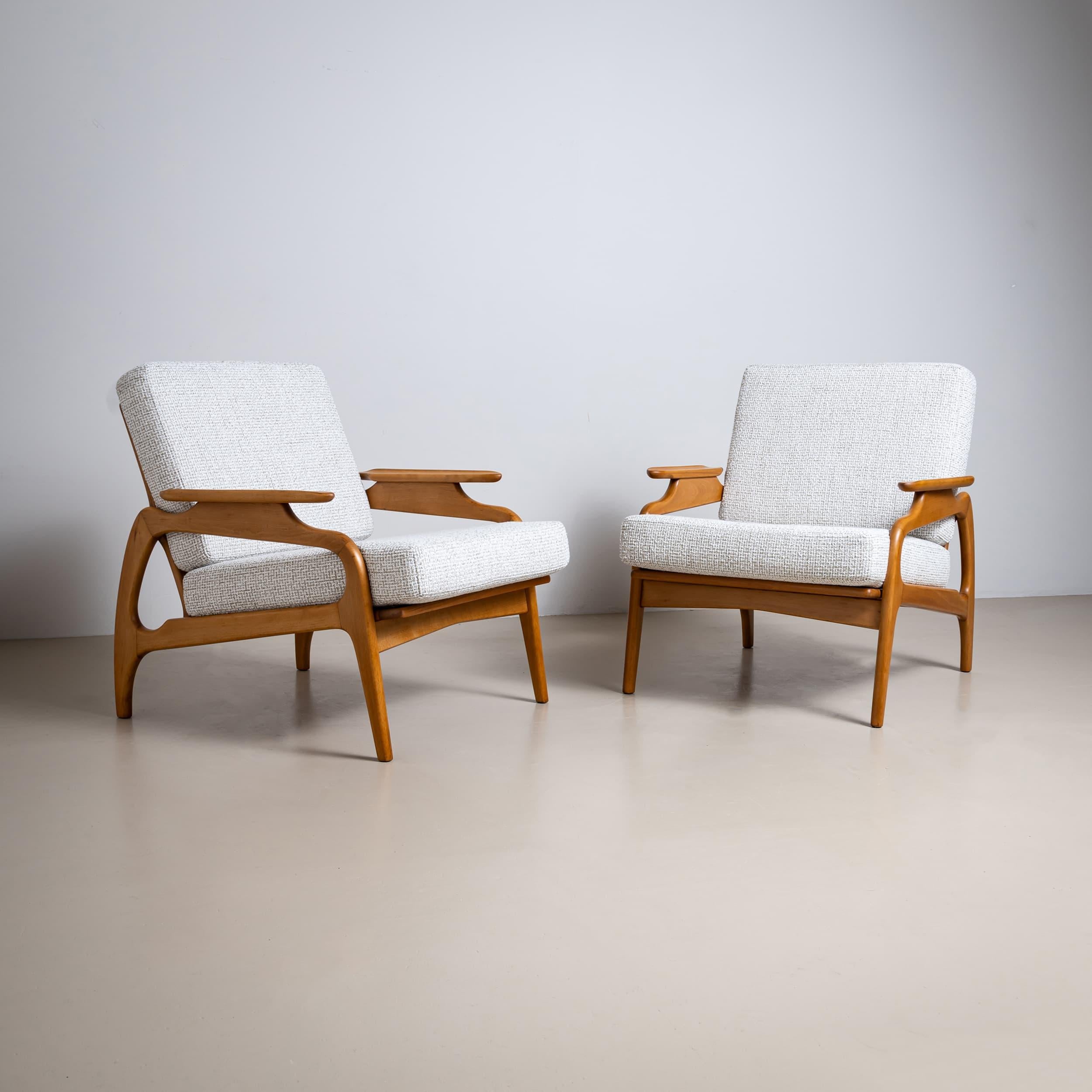 Paire de chaises longues danoises du milieu du siècle dernier des années 1950, fabriquées en bois de hêtre couleur miel. Les accoudoirs de forme distincte soulignent le profil sculptural des chaises.
Les épais coussins d'assise ont été nouvellement