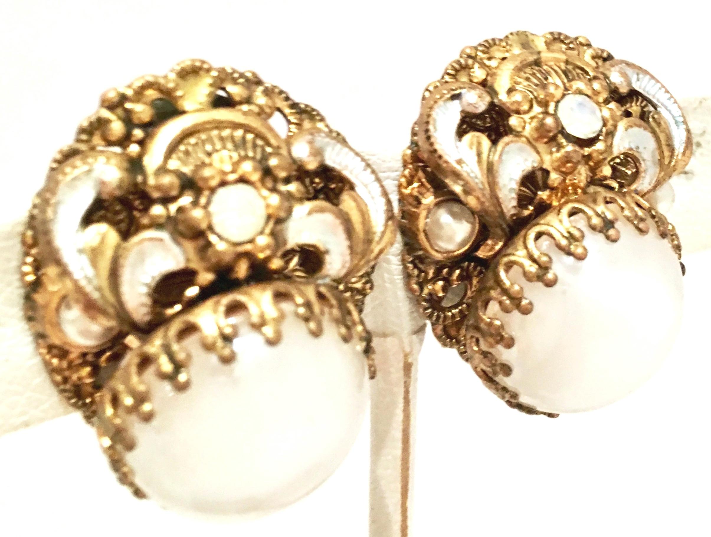 Mid-20th Century Miriam Haskell Style Vermeil Gold & Silver, Molded Glass, Faux Pearl Earrings.
These Art Nouveau style earrings feature a central white opaque polished molded glass central stone with dog tooth prong set detail. Finely crafted and