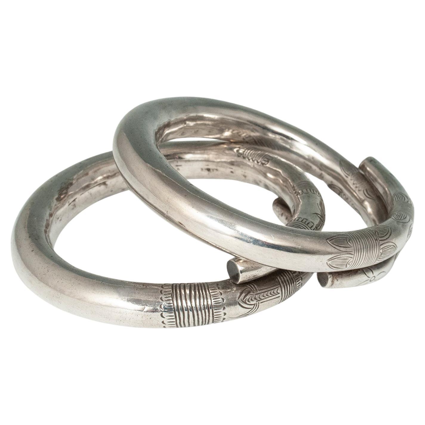 Mid-20th century pair of hollow silver incised bracelets, China

A pair of beautifully made hollow silver bracelets with incised floral and geometric designs. The interior circumference is 8-1/8 inches (20.6 cm), the interior diameter is 2.5