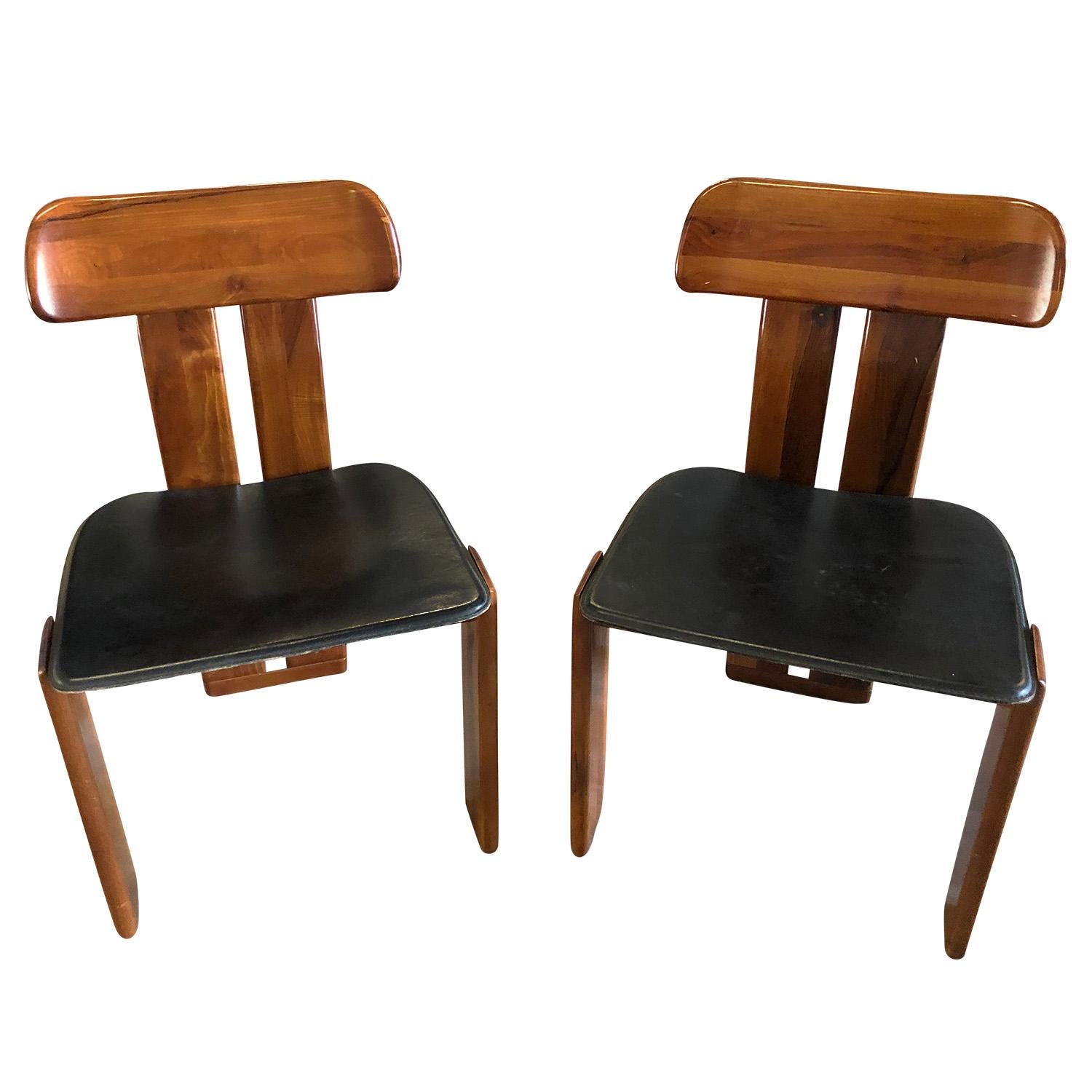 A unique Mid-Century Modern pair of dining chairs made of Rosewood and black leather seats. Designed by Tobia Scarpa in good condition. The side chairs are enhanced by very detailed backrest design, standing on three wide, straight legs. Wear