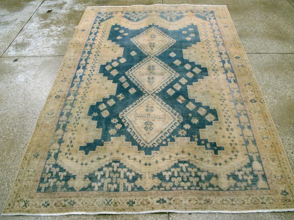 A vintage Persian Afshar accent rug. Three joined, hooked lozenges with palmette cruciform centers form the main attraction on the step-shaped sapphire blue subfield with three points at each end. An inclusive sand subfield displays triple finials