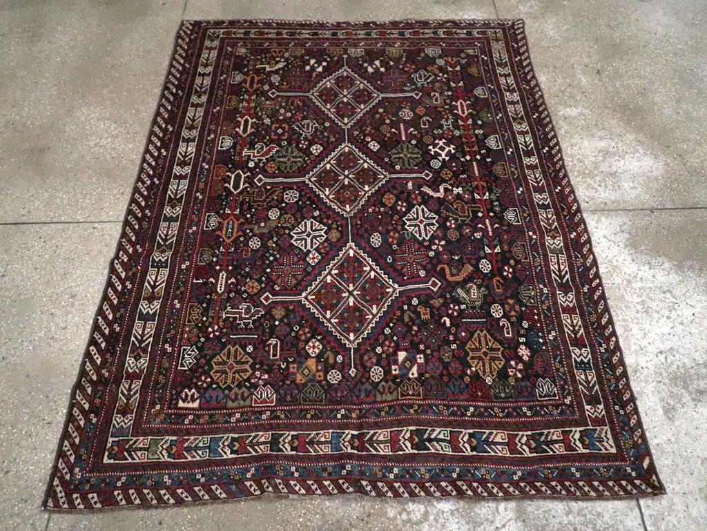 Alfombra de acento persa Afshar vintage. El campo, casi negro, muestra un medallón de asta de triple rombo de marfil con prolongaciones laterales, sostenido por innumerables gallinas, motivos cruciformes, botehs, diminutos octógonos y dispositivos
