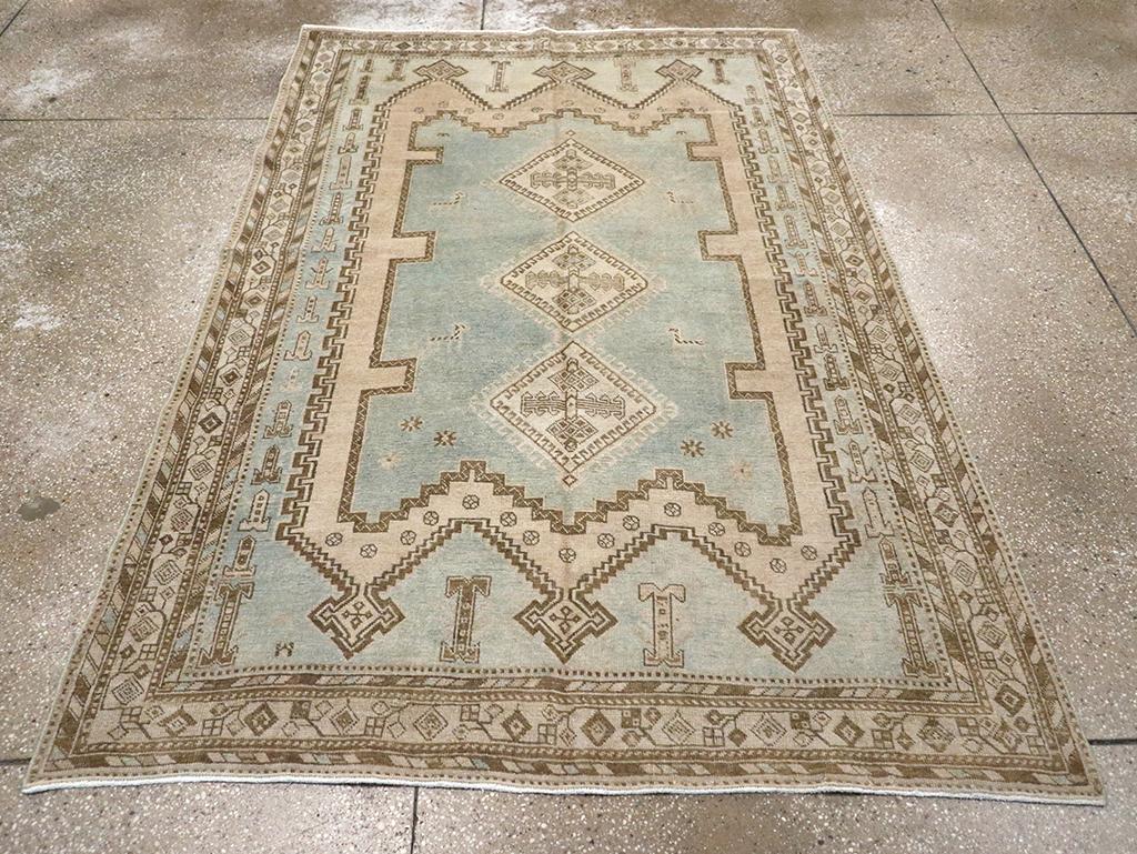 Pole medallion of three connected and hooked ecru diamonds floats freely on the pale blue, side notched panel, further enclosed by a conforming straw sub-field and set on the sky-blue field. Ecru border with lozenge-shaped flowers and a trapezoidal