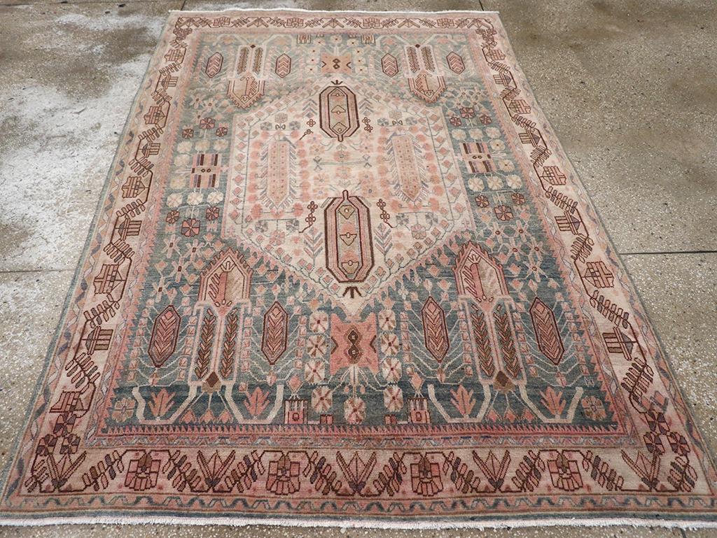 A wool pile of symmetric knots on a cotton foundation. A large ecru hexagonal medallion is set on the slate field, with fringed rocket ship-like forms in the corners and a dense scatter of flowers and blossoms. The central motif encloses two