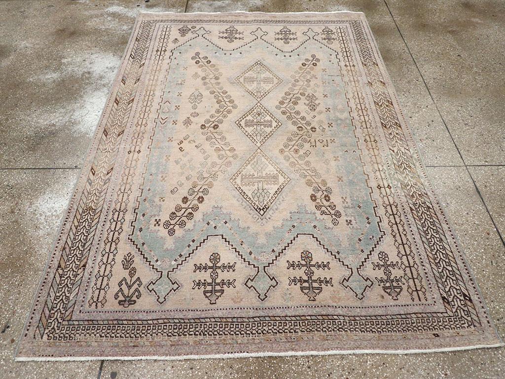 A vintage Persian Afshar accent rug. Here we find the triple triangle crested cartouche without a waist enclosing an ivory pole medallion of three hooked lozenges. A brown zig-zag vine sprout lollipop flowers along the sides of the main reserve. The