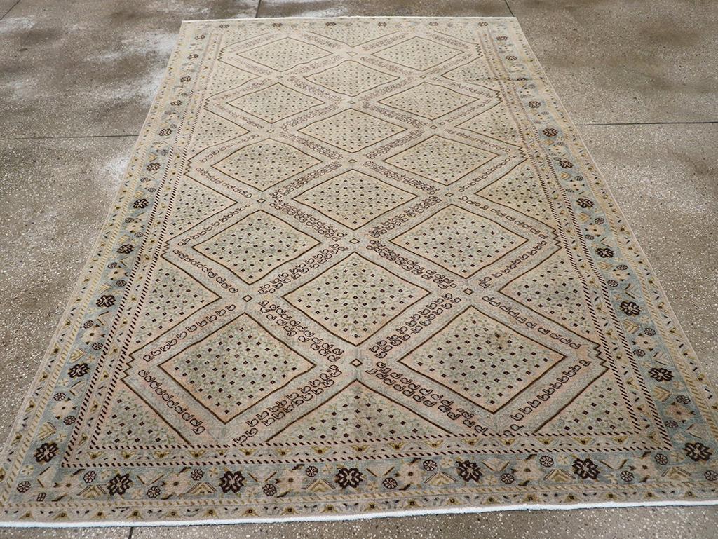 Esta dispersión tribal presenta un montón de nudos asimétricos de lana sobre una base de algodón. Presenta una tonalidad beige-tan-paja con un gran motivo de campo de rombos anidados, acentuado por diagonales de pequeños botes vacíos dispuestos en