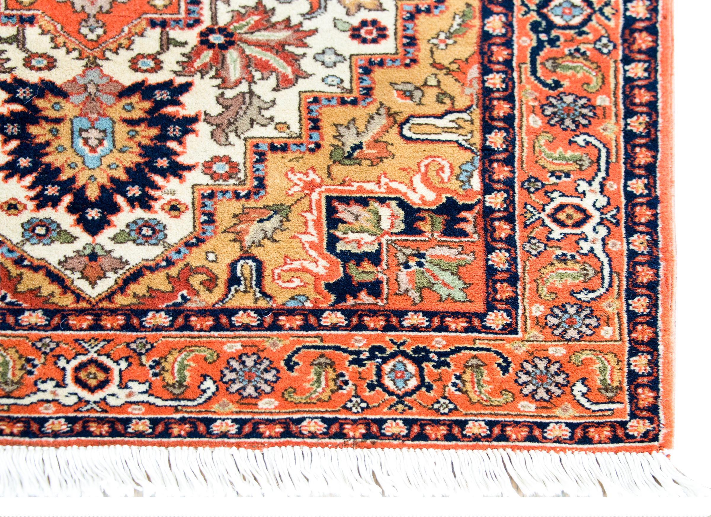 A wonderful mid-20th century Persian Ardabil rug with a large central floral medallion living amidst even more large flowers and leaves, surrounded by a complex border with stylized scrolling vines and flowers, and all woven in orange, gold, light