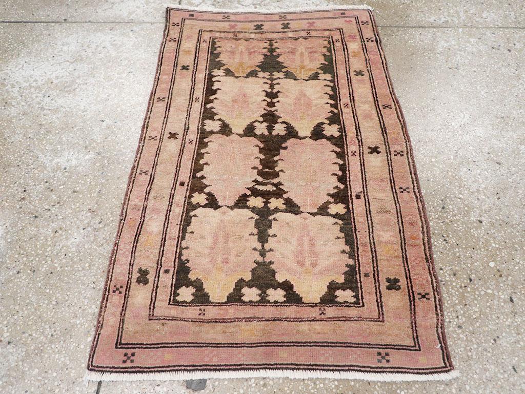 A wool pile of symmetric knots on a cotton foundation. The brick-colored field features eight pinecones enclosing palmettes, with smaller, rounded X motifs filling the spaces. Quincunxes and rotund X’s adorn the three slender borders. The overall