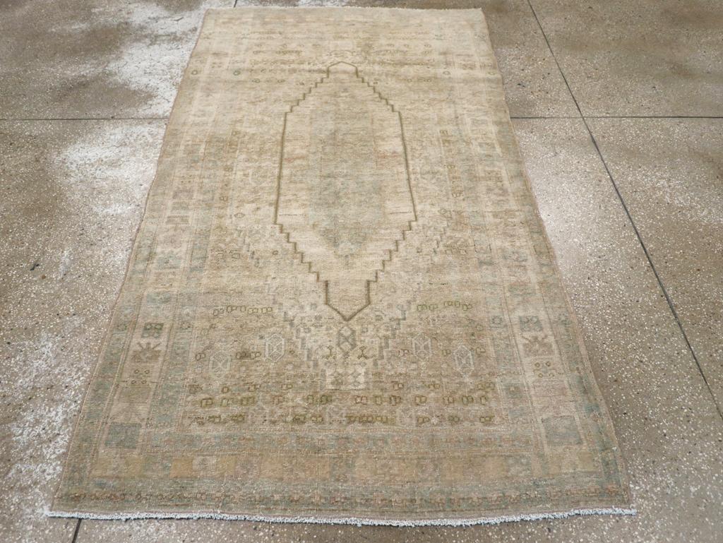 Une pile de laine composée de nœuds symétriques sur une base de coton. Cet objet kurde exceptionnellement pâle présente un champ beige de petites fleurs soutenant un médaillon hexagonal à plusieurs niveaux, haut et étagé. Les tons accentués sont :