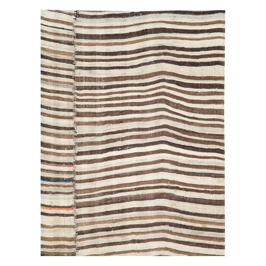 A vintage Persian flat-weave Kilim zebra print small room size rug in gallery format handmade during the mid-20th century. Dark brown, light brown, and cream stripes, among other shades, create the rustic style that works well with modern farmhouse
