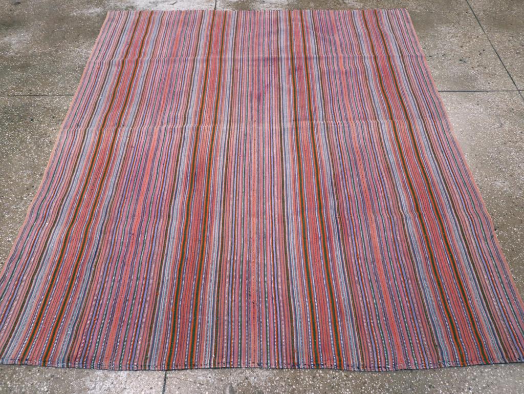 This Mid-20th century Persian Flatweave Kilim rug, measuring 5' 5