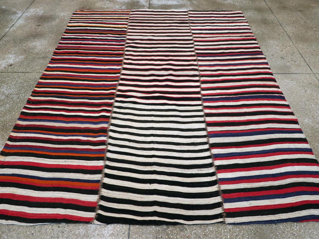 This Mid-20th century Persian Flatweave Kilim rug, measuring 6' 3
