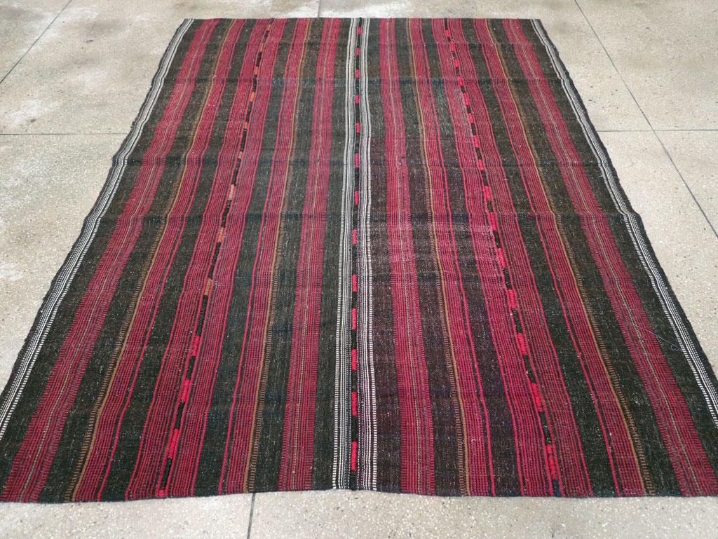This Mid-20th century Persian Flatweave Kilim rug, measuring 6' 3