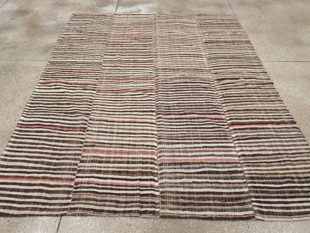 This mid-20th century Persian flatweave kilim rug, measuring 6' 5