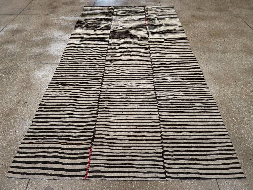 Questo tappeto Kilim persiano a trama piatta della metà del XX secolo, che misura 6' 1