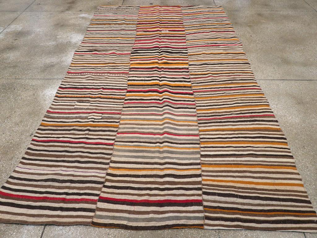 This Mid-20th century Persian Flatweave Kilim rug, measuring 6' 3