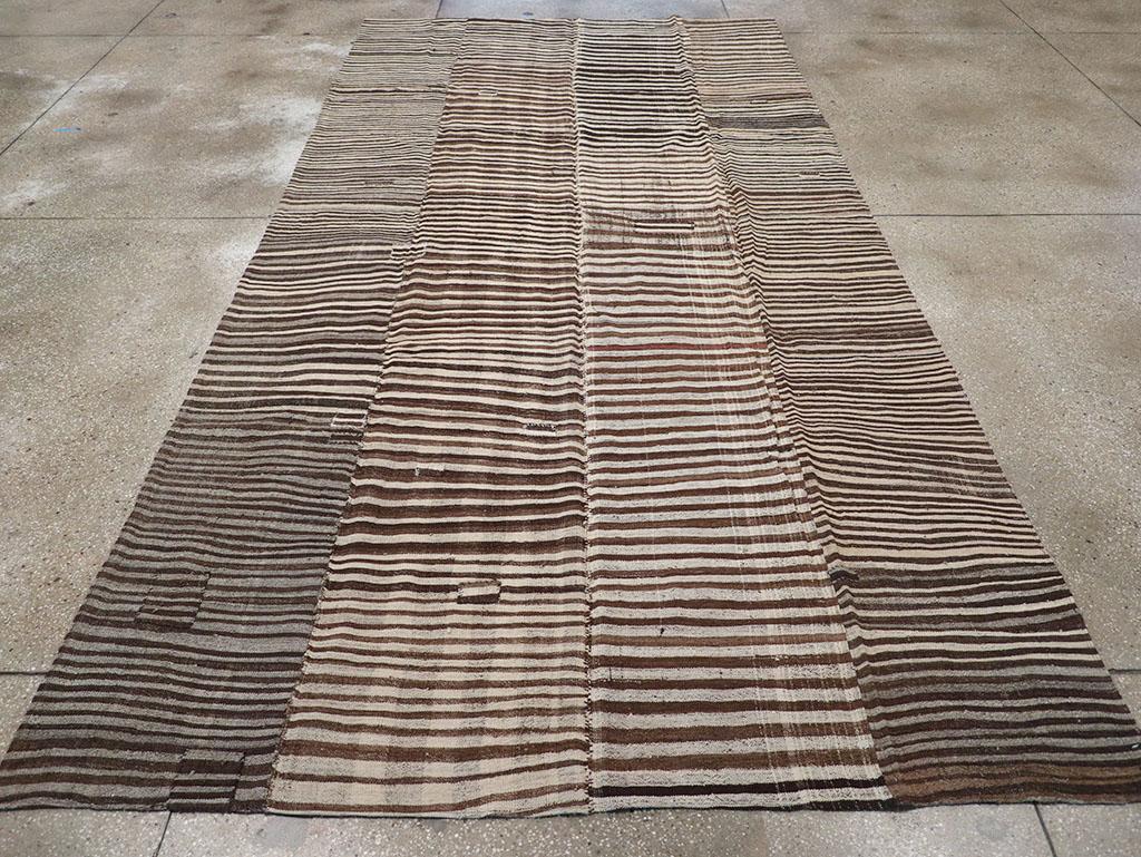 Questo tappeto Kilim persiano a trama piatta della metà del XX secolo, che misura 6' 7