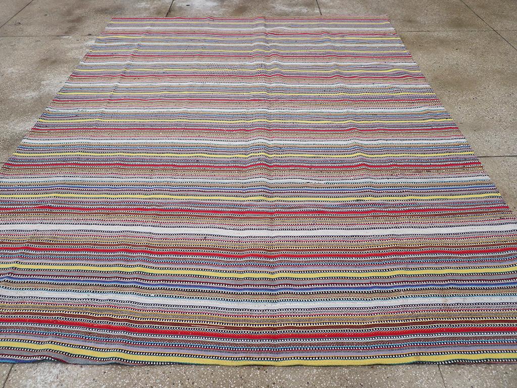 Esta alfombra kilim persa de tejido plano de mediados del siglo XX, que mide 2,8 m x 2,8 m, muestra una vibrante variedad de rayas horizontales multicolores. Tejidas con una divertida combinación de tonos brillantes y apagados, las rayas presentan
