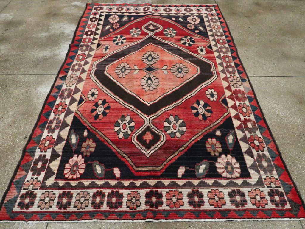 Una alfombra de acento persa Gabbeh vintage. Esta alfombra tribal Qashqai del suroeste de Persia, similar en cierto modo a la alfombra n.º 25204, pero bastante más desgastada, presenta rosetas en el borde de marfil, en el campo rojo estriado, en la