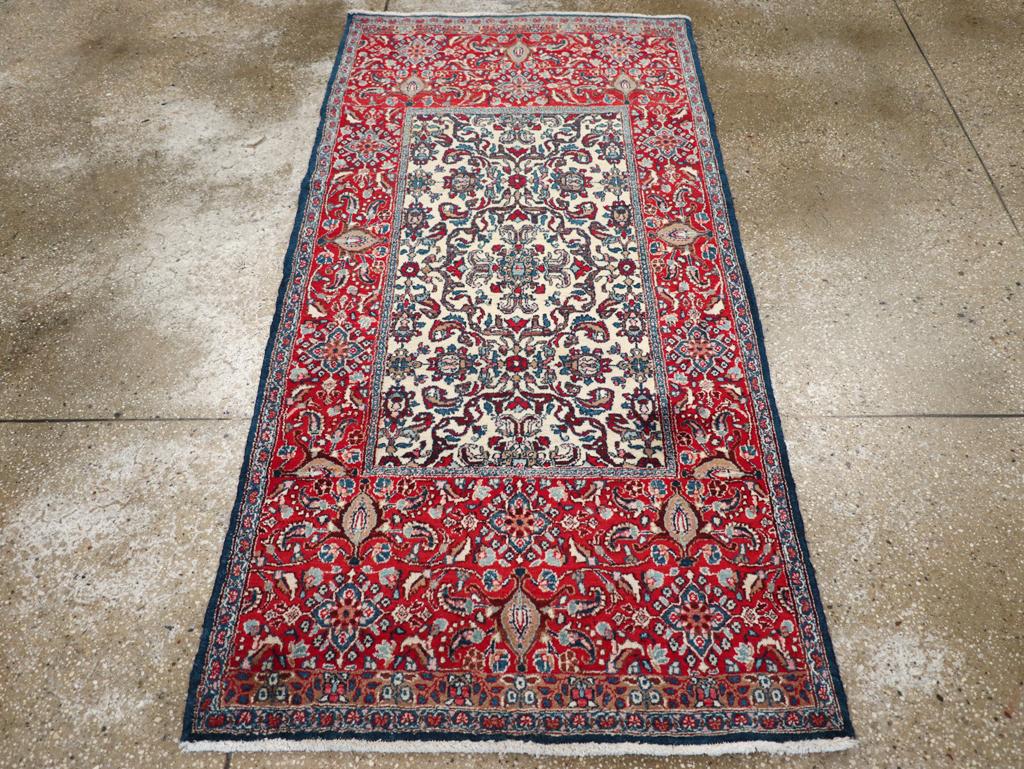 Un tapis persan vintage Isfahan. La bordure rouge est exceptionnellement doublée à chaque extrémité et présente des palmettes de tortue, des cruciformes pointus et des feuilles incurvées. Le champ écru de cette dispersion de ville centrale persane