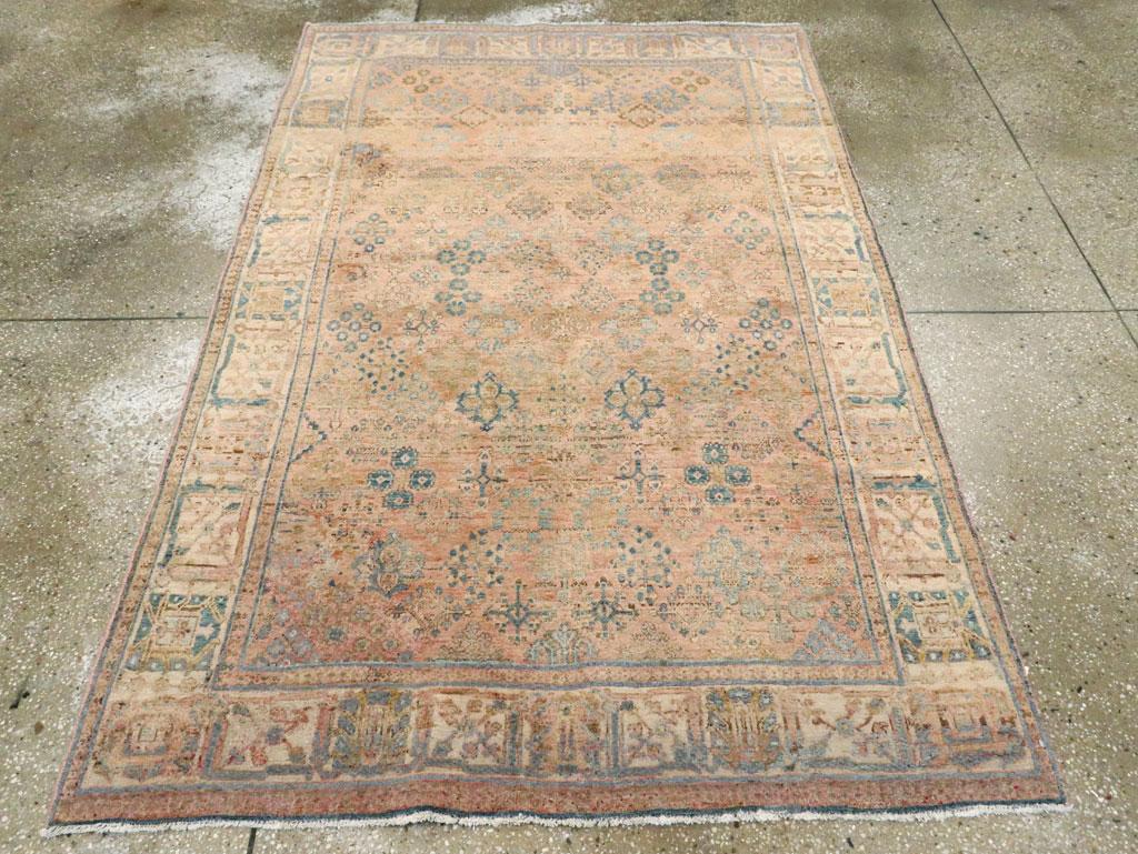 Un Tabriz persiano d'epoca  Tappeto d'accento. Una versione perfetta del classico Joshegan centrale persiano. Il campo in terracotta chiara/salmone è decorato da piccole losanghe fiorite e il bordo avorio presenta palmette e foglie rigide. La