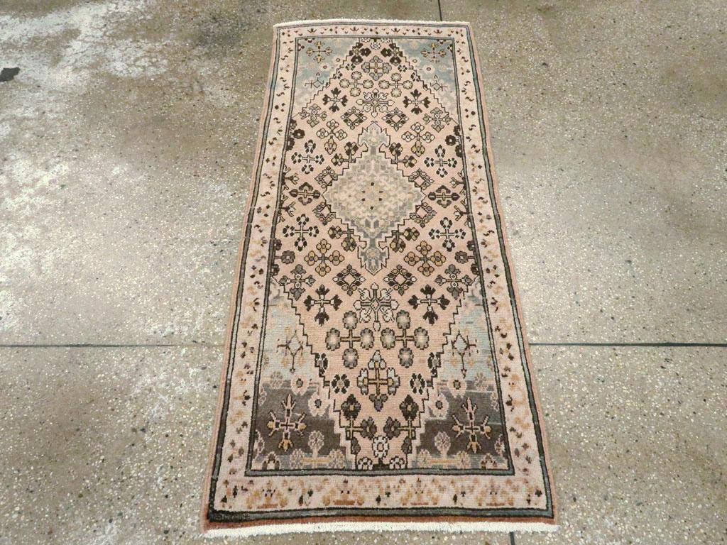 Un tapis persan vintage Josheghan. Ce nanocoureur présente une version simplifiée du motif classique de Joshegan, à savoir des motifs floraux en forme de losange, qui remplissent ici le champ jaune-tan. La bordure ivoire de ce tapis de ville de
