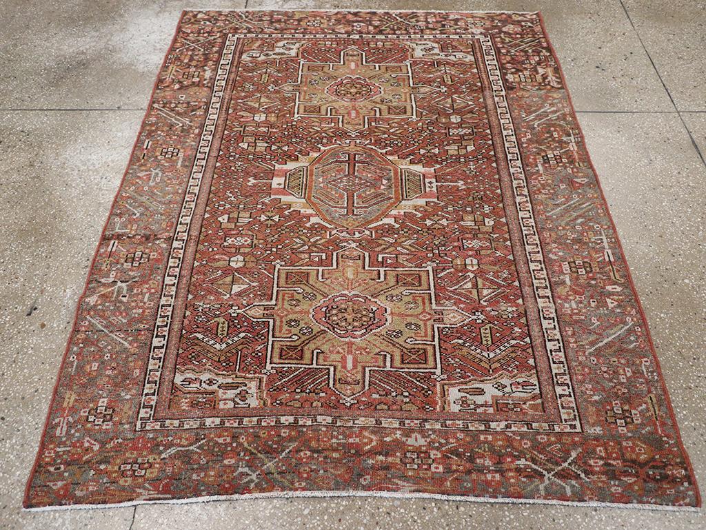 Alfombra de acento persa Karajeh vintage. Dos medallones octogramáticos verde lima en el característico estilo Karajeh flanquean verticalmente un motivo hexagonal en forma de gancho sobre el fondo marrón rojizo con su encantadora dispersión de