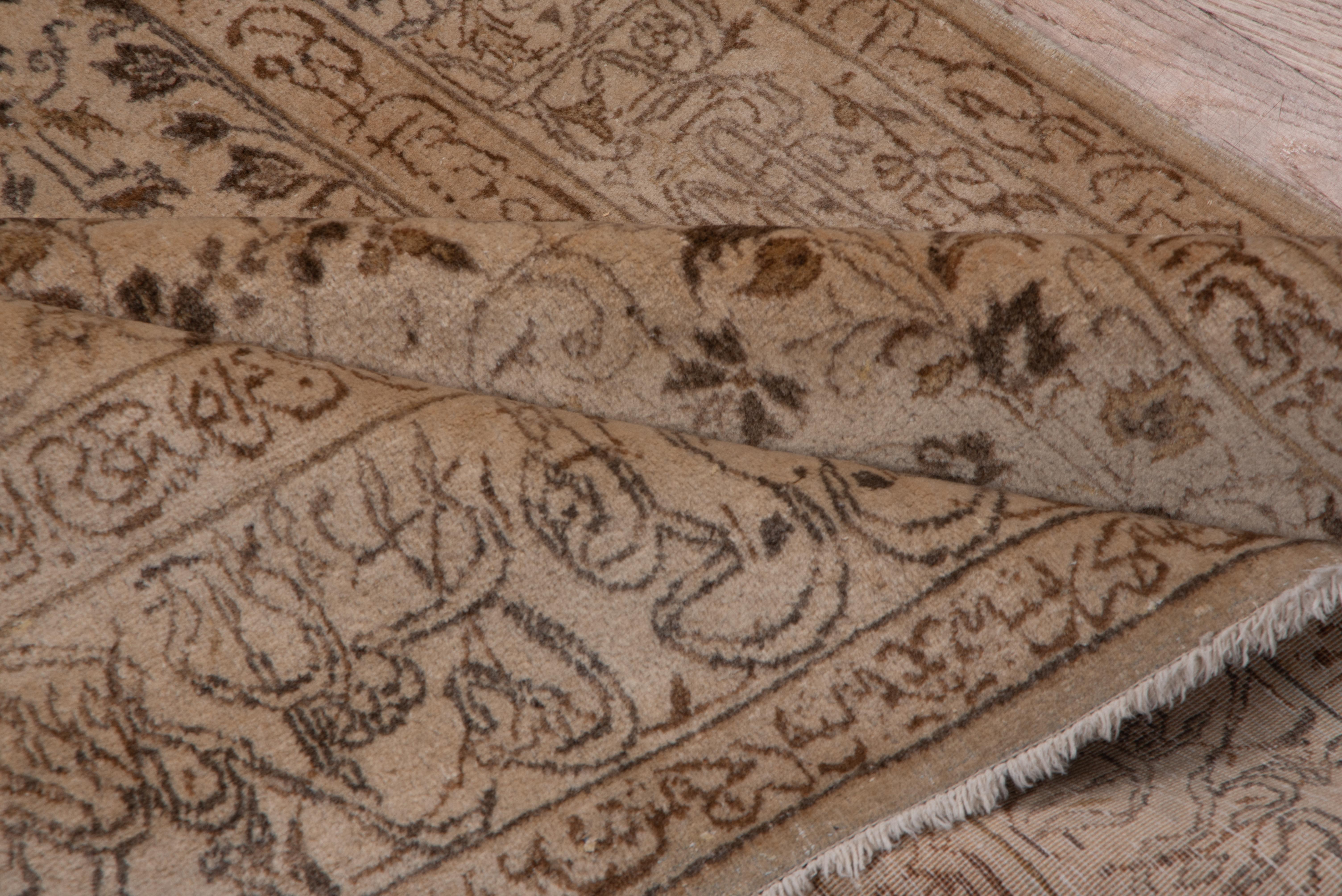 The tan-buff field shows an all-over small palmette and leaf pattern, framed by calligraphic main and minor borders in sand tones. Well-woven, short pile Central Persian city scatter. Good condition.