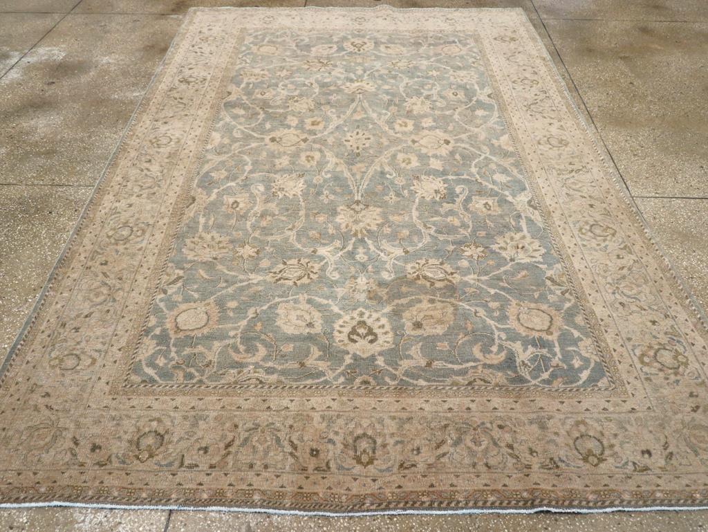 A wool pile of asymmetric knots on a cotton foundation. This piece is in the small carpet rank, with a grey field supporting an allover pattern of four giant, complete spiral arabesques, showing palmettes and leaves, with partial, similar arabesques