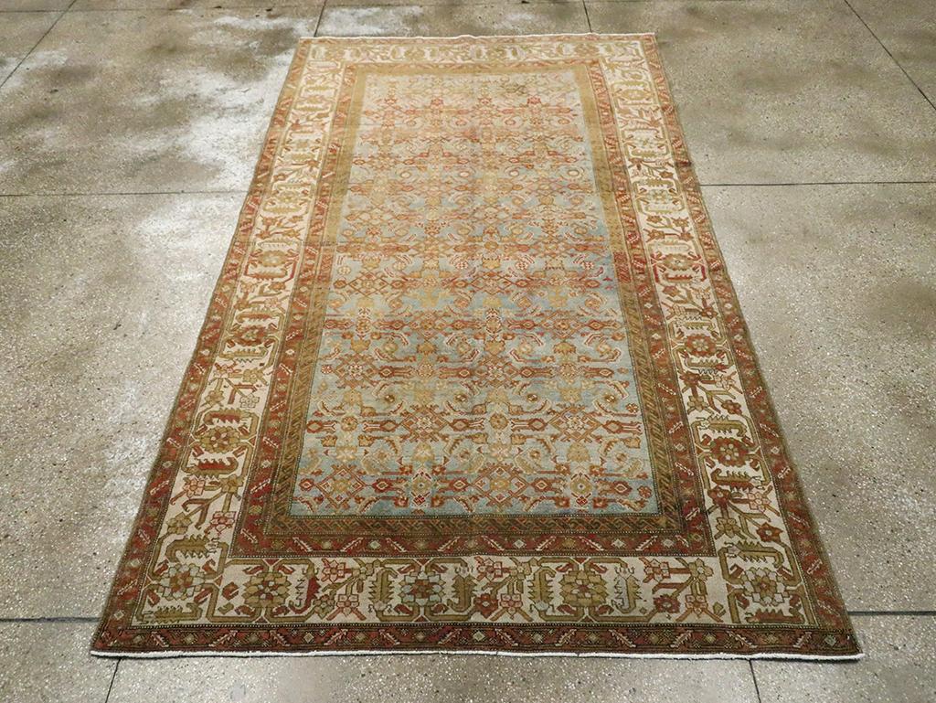 Tapis d'accent persan Malayer vintage. Cette pièce de Perse occidentale de format kellegi présente un motif Herati régulier sur un champ gris-bleu clair. L'orange rouille détaille à la fois les éléments du champ et la bordure de fleurs de mandarine