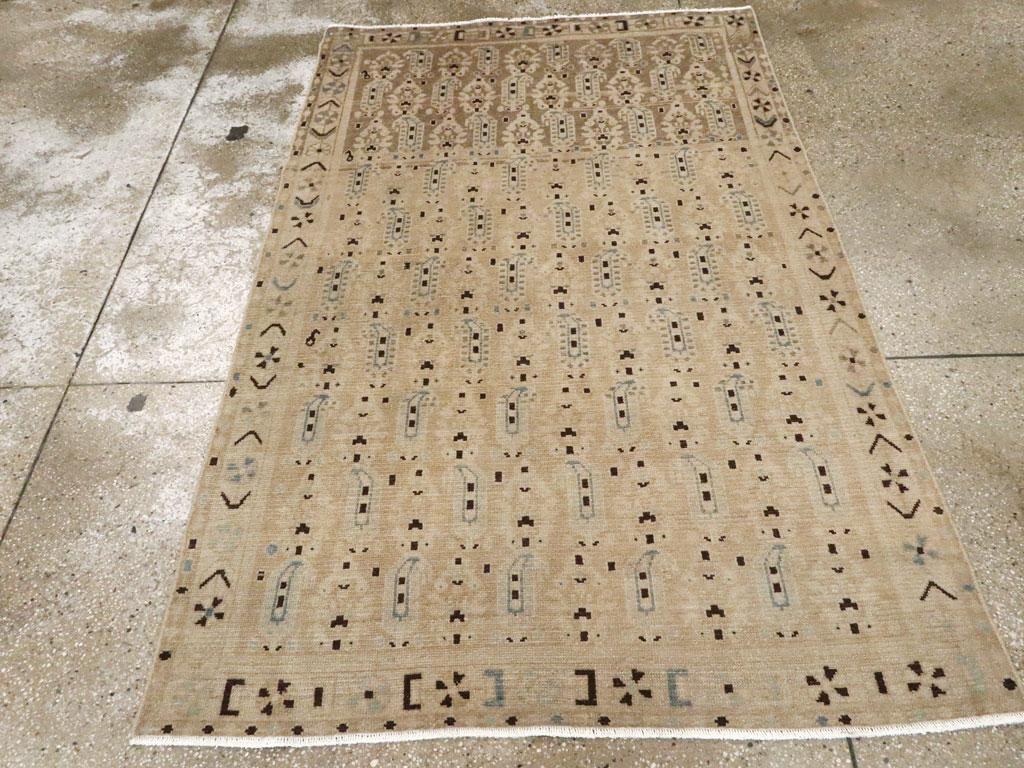 Un tappeto d'accento persiano vintage Malayer. Dieci file invertite di boteh e motivi floreali decorano il campo di paglia e marrone chiaro ben abraso in un motivo tessile allover. Il bordo principale di questo tappeto rustico persiano occidentale