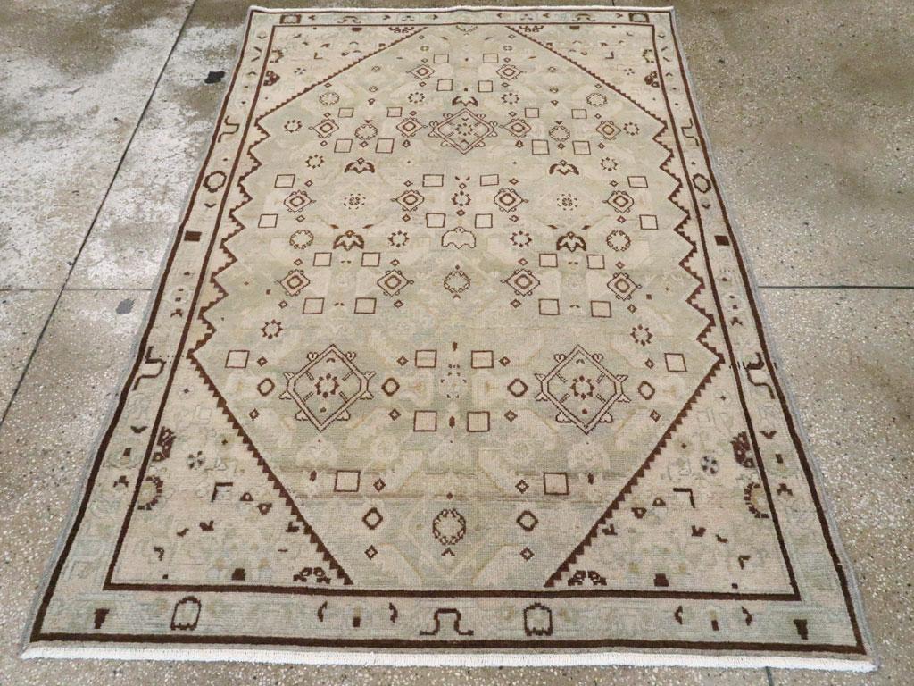 Una alfombra de acento persa Malayer vintage. Esta dispersión de aldeas persas occidentales presenta una paleta de beige y marfil viejo con detalles en ámbar oscuro en el motivo Herati general, en el subcampo escalonado y en zig-zag, en las franjas