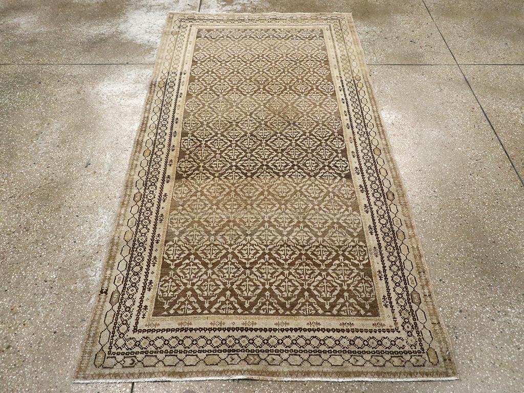 Una alfombra de acento Perisan Malayer vintage. Esta alfombra rústica de acento persa del oeste presenta un fondo marrón oscuro con hileras de rombos a media altura que encierran flores sencillas. Los bordes incluyen un marco exterior con garabatos