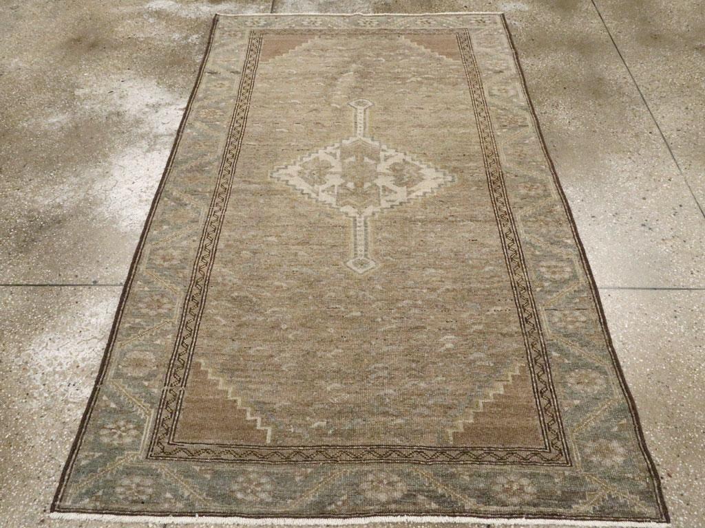 Ein alter persischer Malayer Akzentteppich. Dieses erdfarbene westpersische Dorfstreu zeigt ein altes elfenbeinfarbenes, gestuftes Rautenmedaillon mit langen, vertikalen Pfeilspitzen auf einem blattgeschmückten Feld. Die mittelgroße schieferfarbene