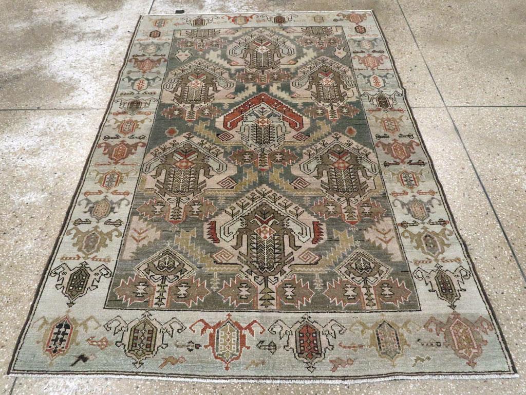 Un tapis d'accent persan Malayer vintage. Le champ brun bien dissimulé et abrasé présente trois colonnes en demi-goutte de palmettes audacieuses dans un motif à sens unique. La paille, l'ivoire, le brun rouge, l'abricot brûlé et l'ivoire font partie