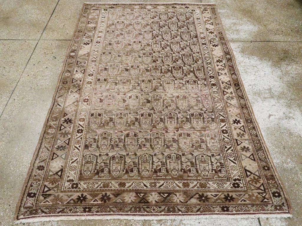 Ein alter persischer Malayer Akzentteppich. Reihen von stilisierten Botehs stehen dicht gedrängt auf dem abgewetzten braunen Feld. Ungewöhnlich ist, dass der Abrieb auf und ab und nicht quer über den Teppich verläuft. Eine Schneeflocke und eine