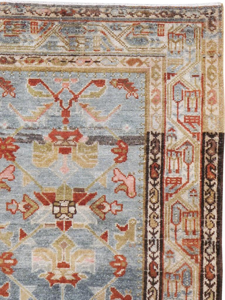 Ein alter persischer Malayer Akzentteppich. Das blaue, stark abgewetzte Feld zeigt ein abstraktes Gitter- und Blattmuster, das mehrere rotbraun umrandete Palmettenstile einschließt. In dieser westpersischen Dorfstreuung kommen Botehs in allen drei