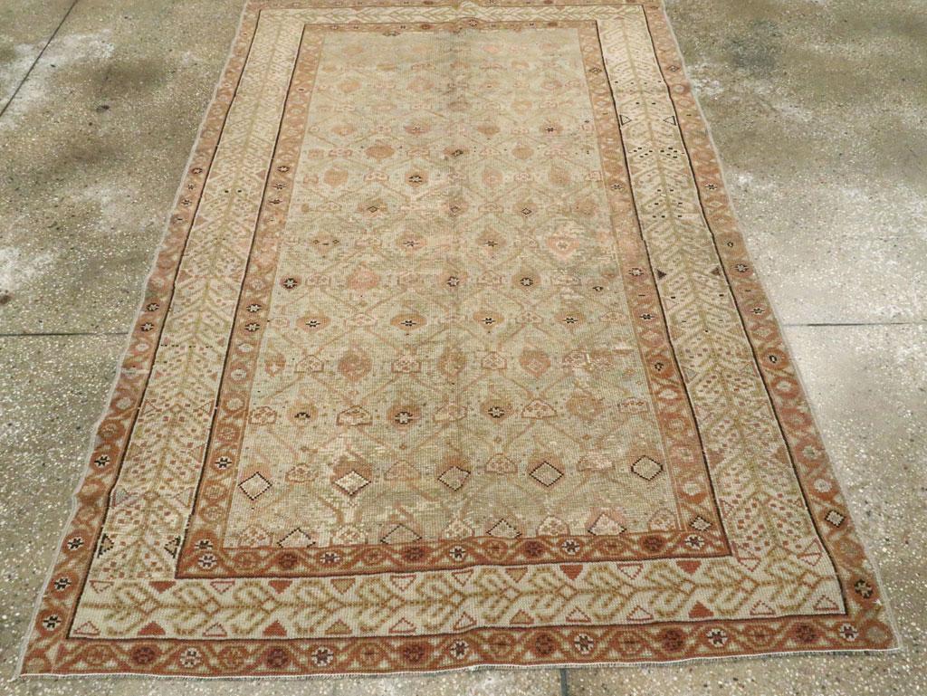 Un tapis d'accent persan Malayer vintage. Le champ de perles est doté d'un treillis octogonal étiré verticalement et renfermant des formes florales irrégulièrement dessinées. Il est encadré par une bordure principale ivoire avec un motif progressif