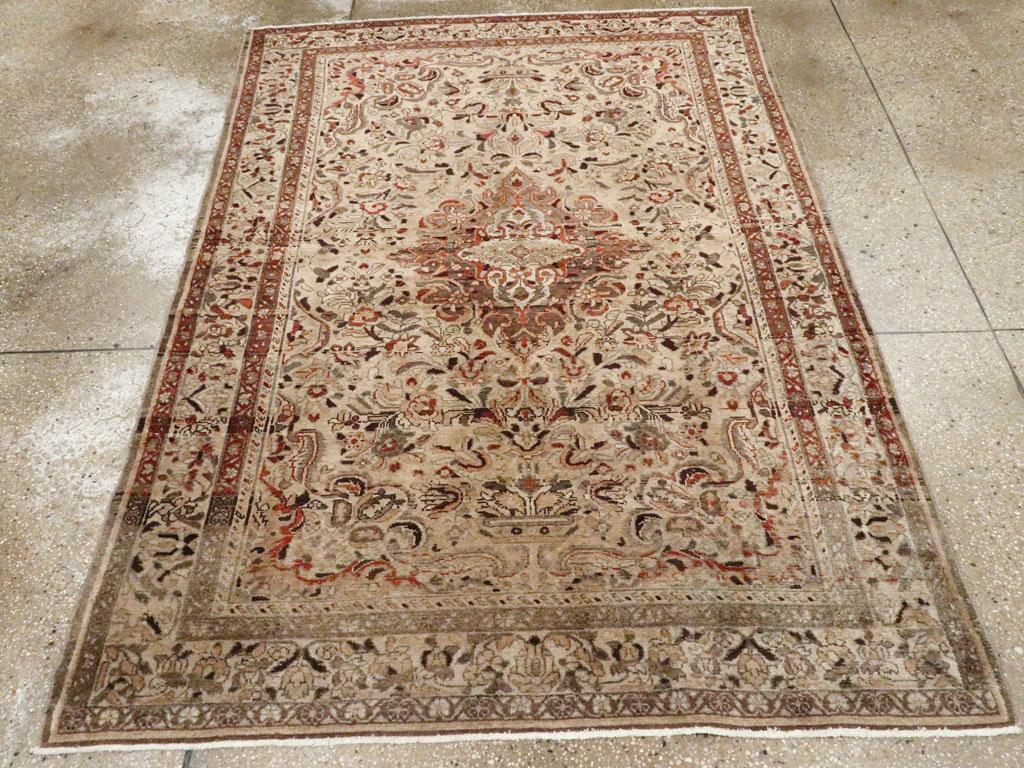 Un tapis d'accent persan Malayer vintage. Le champ chamois présente un motif floral curviligne autour du médaillon brun-ombre abrasé au contour complexe, presque baroque. La bordure principale de ce tapis de banlieue ouest-persan est également dans