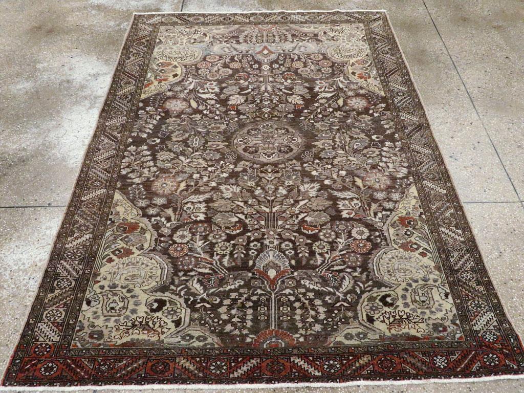 Un tapis d'accent persan Malayer vintage. Le champ brun foncé présente un motif floral détaché tourbillonnant autour d'un médaillon central ovale et entouré de coins jaunes lobés de conception similaire. La bordure gris-vert est plus géométrique,
