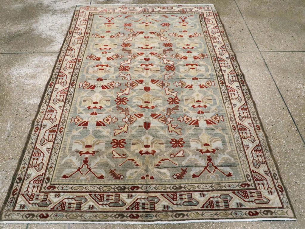 A vintage Persian Malayer accent rug. An ivory border with faceted vine enclosing small pendant botehs frames the abrashed light grey field with a lattice and two-way palmette pattern in three columns.  Boteh chains decorate both inner and outer