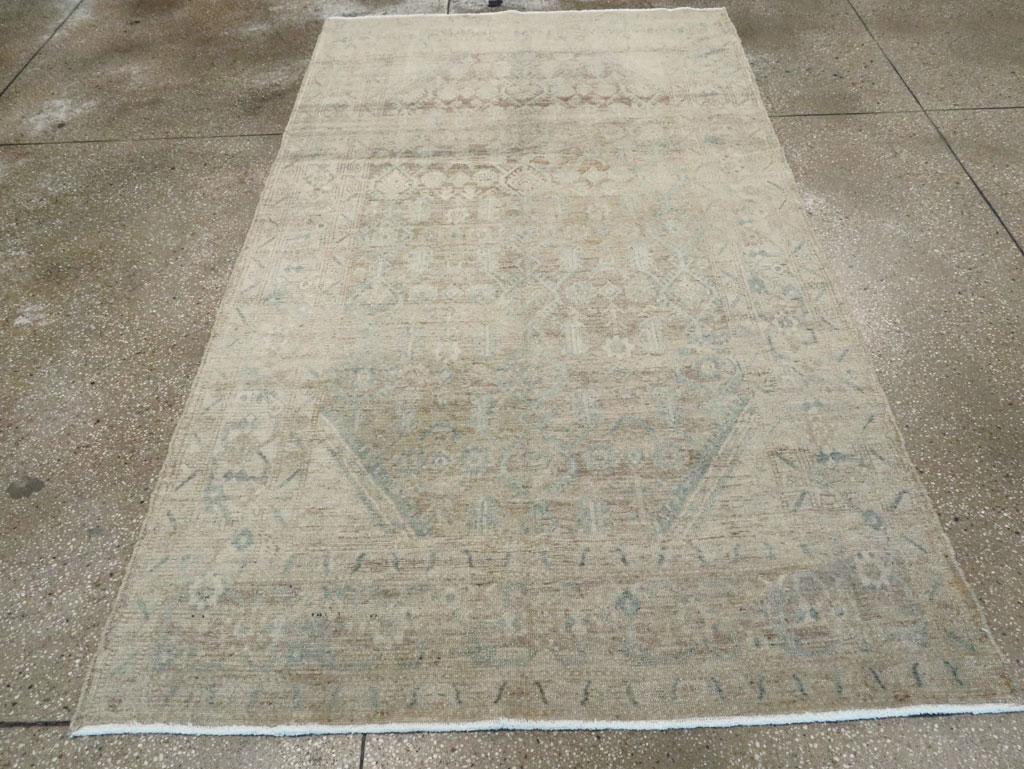 A vintage Persian Malayer accent rug. The abrash is the most noticeable feature of this very tonally reduced west Persian long rug with an allover Herati-style design in tones of sienna brown, cream, sand and straw on a ground changing from