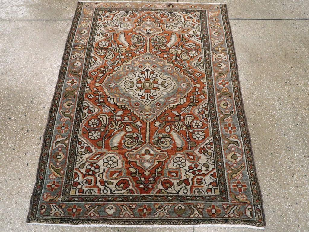 Ein alter persischer Malayer-Teppich. Das rotbraun gestaltete Feld zeigt ein sanft gelapptes und hängendes grünes Medaillon vor elfenbeinfarbenen einfachen Lanzettblättern und blühenden Ranken.  Die Elfenbeinecken schließen sich eng an die übrige