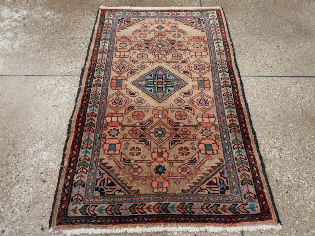 A vintage Persian malayer throw rug. The golden camel field gives the central blue lozenge medallion plenty of room. He weaver has included all the Herat design elements, but not integrated them into a formal pattern. The ivory herringbone border is