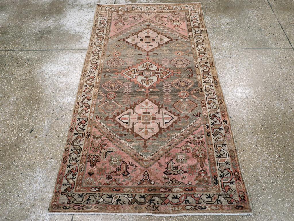 Ein alter persischer Malayer-Teppich. Die spitz zulaufenden, kreuzförmigen Rautenmedaillons in Beige und Elfenbein werden auf dem Schiefergrund von winzigen, beblätterten Blüten getragen. Ein unzusammenhängendes Herati-Muster füllt jede