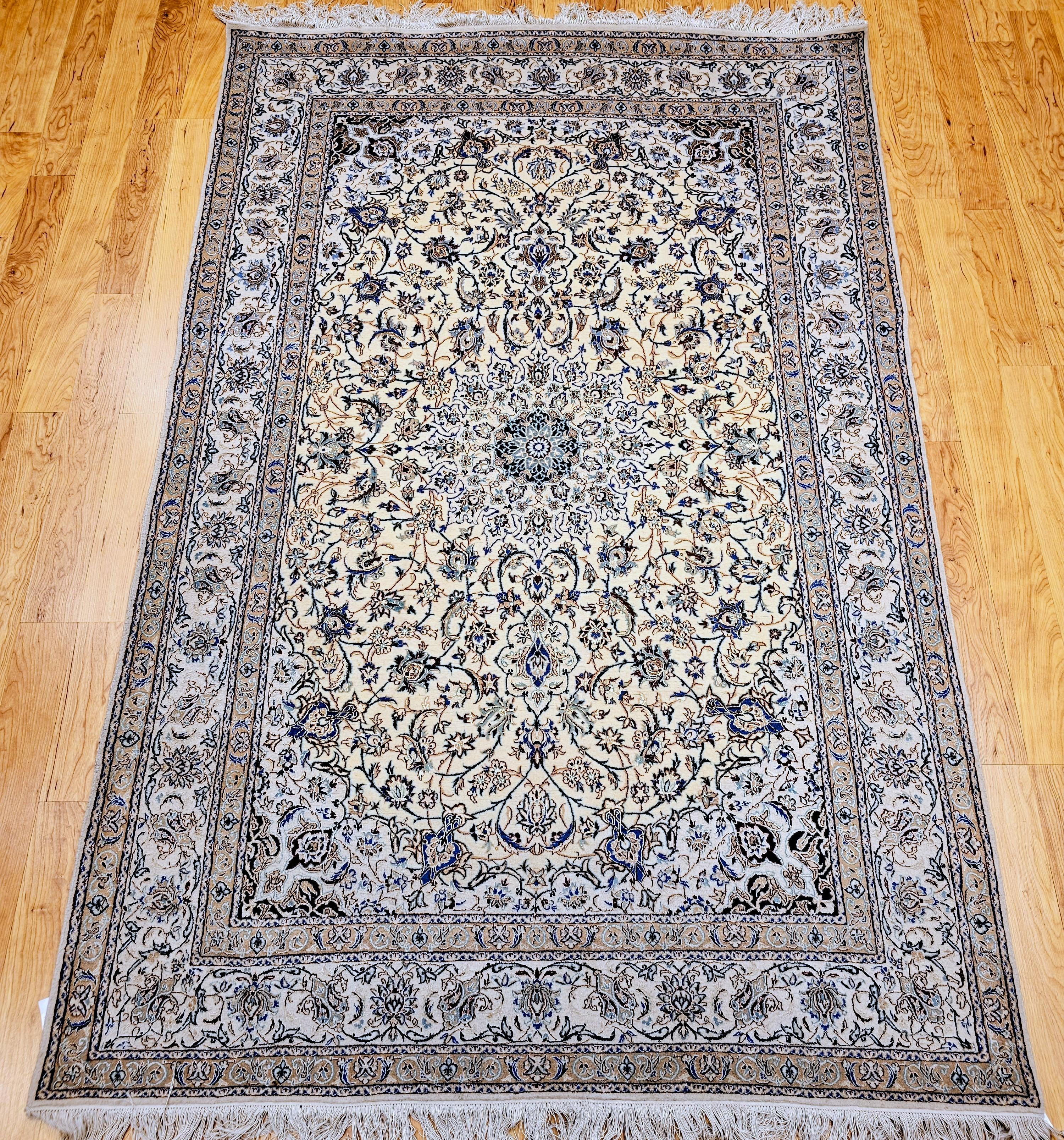 Dieser handgewebte persische Nain-Teppich aus dem 3. Viertel der 1900er Jahre ist ein exquisites Beispiel für die berühmte Handwerkskunst der Stadt. Mit einem feinen Wollflor auf einem Baumwollgrund gewebt und mit schimmernden Seidenakzenten