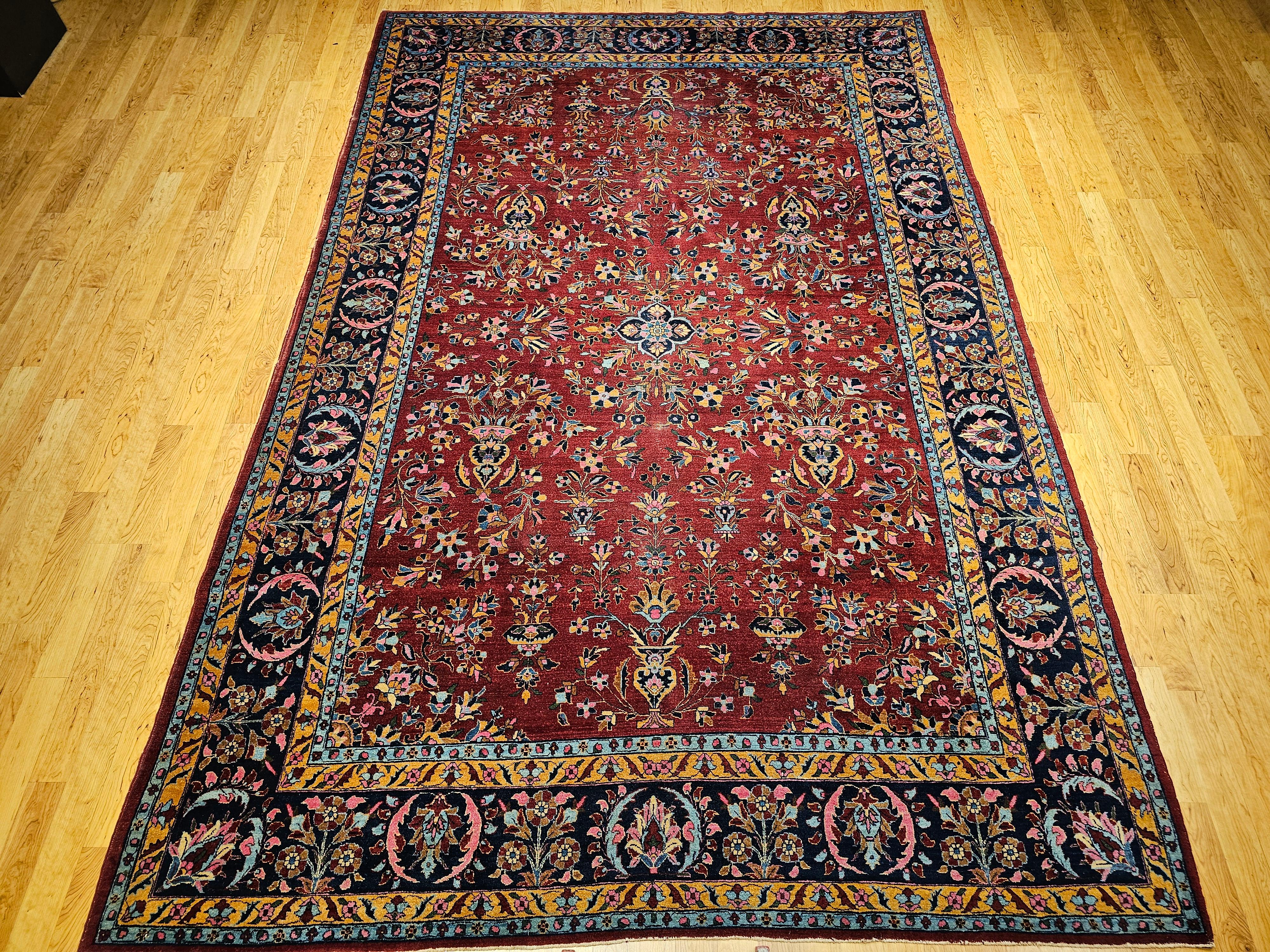 Ein prächtiger persischer Sarouk-Teppich aus der Mitte des 20. Jahrhunderts, wunderschön handgeknüpft mit einem detailreichen floralen Allover-Muster. Dieses elegante, raumgroße Stück zeigt ein leuchtend rotes Feld mit floralen Vasenmotiven und