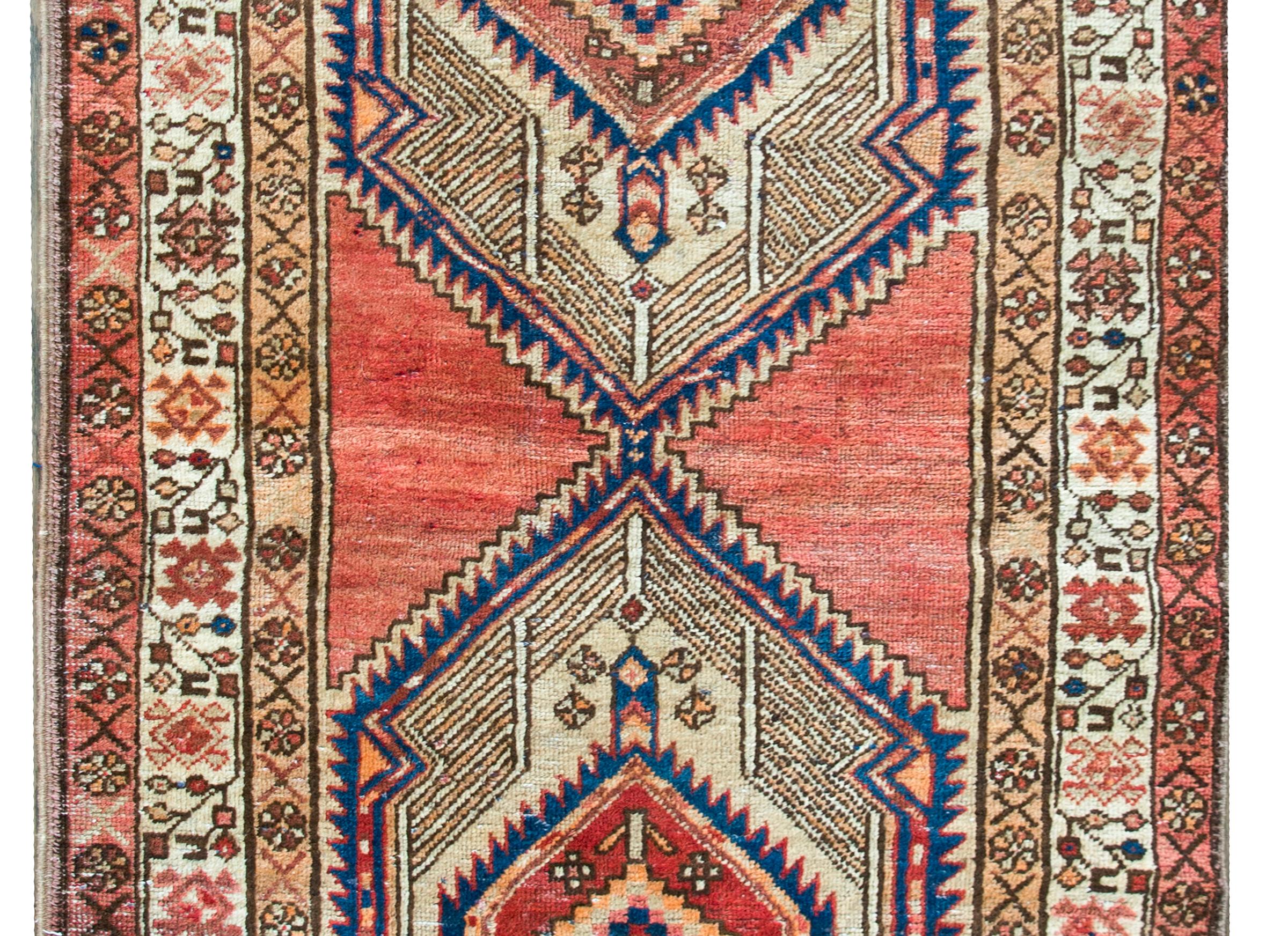 Fantastique tapis persan Serab du milieu du 20e siècle, avec deux grands médaillons centraux en forme de diamant, chacun avec une fleur centrale stylisée et entouré de motifs géométriques.  La bordure est complexe, avec trois bordures stylisées à