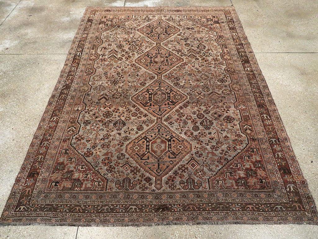 A vintage Persian Shiraz accent rug. A brown central pole medallion of four attached diamonds, each centering a symmetrized turtle palmette, is set on a dove grey sub-field intensely covered with a multitude of spring flowers and set on a brown